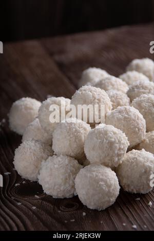 Foto viele weiße Schokoladenbonbons mit Kokosnussgeschmack, die übereinander auf dem Tisch liegen, süß, Dessert, Zucker, Kokos Stockfoto