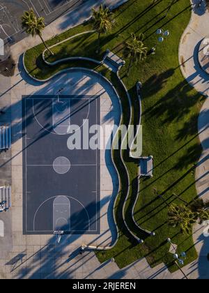 Top-Down-Luftaufnahme des Basketballplatzes und der kurvigen Landschaft rund um den Venice Beach in Los Angeles. Stockfoto