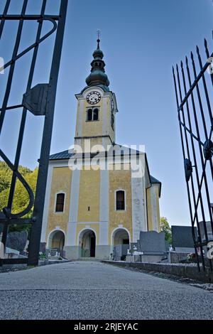Sehr alte gelbe traditionelle europäische Architekturkirche auf dem Hügel in Srednja Vas V Bohinju in der Nähe des Bohinjer Sees. Nationalpark Triglav. Slowenien. Stockfoto
