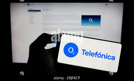 Person, die ein Mobiltelefon mit dem Logo der Firma Telefonica Deutschland Holding AG auf dem Bildschirm vor der Geschäftswebseite hält. Konzentrieren Sie sich auf das Display des Telefons. Stockfoto