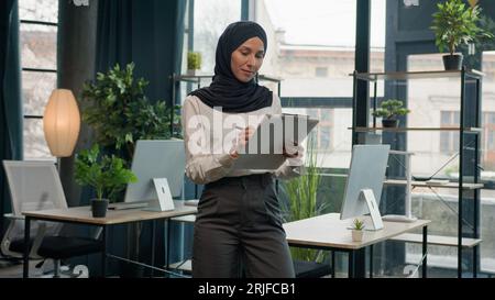 Islamisch muslimische indische Araberin Geschäftsfrau Manager Business Recruiter Mädchen im Hijab inspizieren im Büro schreiben auf Notizblock schreiben Notizen unterschreiben Stockfoto