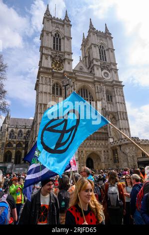 LONDON – 22. April 2023: Legendäre Kulisse: Protestprotestierende der Extinction Rebellion mit Protestflaggen veranstalten eine Kundgebung vor der majestätischen Westminster Abbey Stockfoto