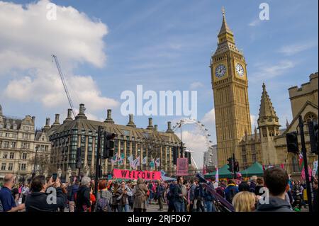LONDON – 22. April 2023: Eindrucksvoller Hintergrund: Demonstranten der Extinction Rebellion, aufgestellte Banner, stehen vor berühmten Wahrzeichen - Parlament und London Eye Stockfoto