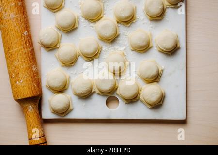 Rohe hausgemachte Knödel auf einem Marmortablett. Stockfoto