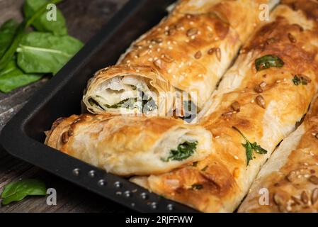 Frischer hausgemachter Kuchen mit Spinat auf einem Holztisch Stockfoto