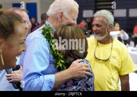 Lahaina, Vereinigte Staaten. August 2023. US-Präsident Joe Biden, Center, umarmt einen Bewohner während eines Gemeindetreffens nach den Waldbränden, die im Lahaina Civic Center, 21. August 2023 in Lahaina, Maui, Hawaii, über West Maui gefegt haben. Quelle: Adam Schultz/White House Photo/Alamy Live News Stockfoto