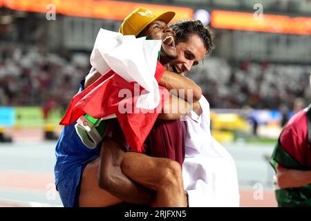 Der Italiener Gianmarco Tamberi (rechts) feiert den Goldgewinn im Männer-Hochsprung mit Katars Mutaz Essa Barshim, der am vierten Tag der Leichtathletik-Weltmeisterschaften im National Athletics Centre in Budapest, Ungarn, Bronze gewann. Bilddatum: Dienstag, 22. August 2023. Stockfoto