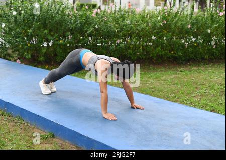 Hübsche asiatische Frau, die Stretching-Aktivitäten im Park für Gesundheit und gute Form macht. Stockfoto