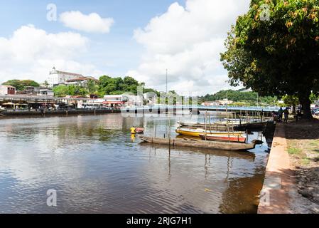 Valenca, Bahia, Brasilien - 10. Januar 2023: Blick auf den Fluss Una, umgeben von Pflanzen, Bäumen und Geschäftsgebäuden. Touristenstadt Valenca im Stockfoto