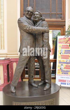 Bronzestatue von Eric Morecambe und Ernie Wise, die sich am Eingang zu den Wintergärten in Blackpool umarmen Stockfoto