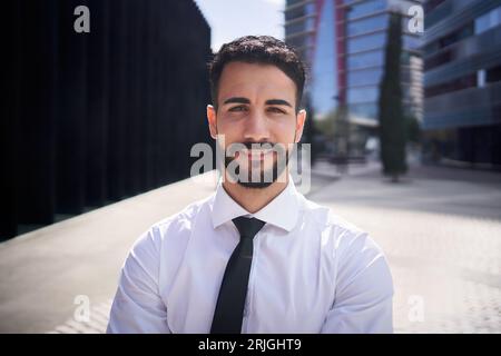 Porträt attraktiver junger, selbstbewusster junger Geschäftsmann, der vor dem Bürogebäude posiert. Leerzeichen kopieren. Stockfoto