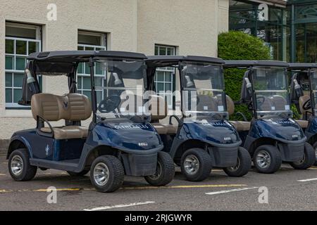 Gleneagles, Schottland, Vereinigtes Königreich - 13. August 2023 - Blaue Golfbuggys auf dem Gleneagles Golfplatz in einer Reihe geparkt Stockfoto