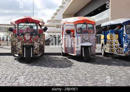Tuck-Tuck-Fahrer, die auf die Kunden am Taxistand des Kreuzfahrthafens warten, in ihren hochdekorierten Maschinen, Lissabon, Portugal, April 2023. Stockfoto