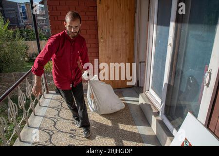 August 2023, Srinagar, Jammu und Kaschmir, Indien: ein Mitarbeiter von „Kashmir Walla“ trägt einen Sack voller Büromagazine, während er sein Büro in Srinagar verlässt, da ihm ein Tag nach der Blockierung der Website und der Social-Media-Handles durch die indischen Behörden durch den indischen Informationstechnologiegesetz von 2000 eine Räumungsmitteilung zugestellt wurde. laut einer von der Nachrichtenagentur veröffentlichten Erklärung. „Die Kaschmir-Walla“ ist eine prominente unabhängige Nachrichtenwebsite mit Sitz in Kaschmir, die 2009 von dem Gründer und Herausgeber Fahad Shah gegründet wurde, der derzeit wegen Medienberichterstattung 18 Monate im Gefängnis sitzt Stockfoto