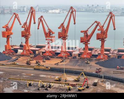 YANTAI, CHINA - 22. AUGUST 2023 - Frachtschiffe und -Züge transportieren Kohle im Longkou-Hafengebiet im Yantai-Hafen in der ostchinesischen Provinz Shandong, 22. August 2 Stockfoto