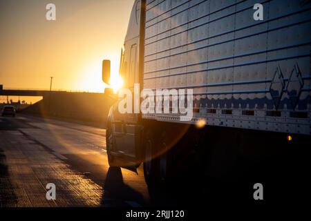 Langstreckenwagen mit 18 Rädern bei Sonnenaufgang oder Sonnenuntergang Stockfoto