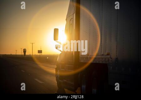 Langstreckenwagen mit 18 Rädern bei Sonnenaufgang oder Sonnenuntergang Stockfoto