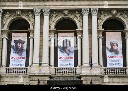 Nicht exklusiv: LEMBERG, UKRAINE - 21. AUGUST 2023 - Plakate, die den Abenteuerfilm Dovbush bewerben, schmücken die Fassade der Solomiya Krushelnytska Lviv Stockfoto