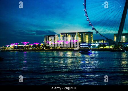Dubai Marina in Dubai, Vereinigte Arabische Emirate. Blick auf die Wolkenkratzer und den Kanal. Blick bei Nacht, Riesenrad Stockfoto