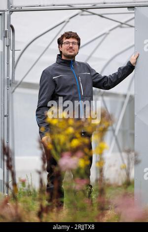 Bohmte, Deutschland. August 2023. Robert Franz, Gärtnermeister am DFKI, steht vor einem Gewächshaus. Das Deutsche Forschungszentrum für Künstliche Intelligenz (DFKI) betreibt Forschung und Entwicklung auf dem Gebiet der Agrarrobotik. Das DFKI testet auf einem ehemaligen Golfplatz bei Bohmte künstliche Intelligenz für die Landwirtschaft. (An dpa „Ein Trainingscamp für Roboter in der Landwirtschaft“) Credit: Frisch Gentsch/dpa/Alamy Live News Stockfoto