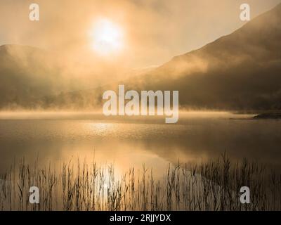 Nebel am frühen Morgen über dem Brothers Water Lake, im Seenviertel, Cumbria, England, Großbritannien Stockfoto