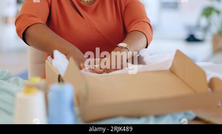 Schwarze Frau, Hände und Box in der Logistik für Lieferung, E-Commerce oder Versand von Fracht am Büroschalter. Die Hand der afroamerikanischen Frau im Kleinbetrieb Stockfoto