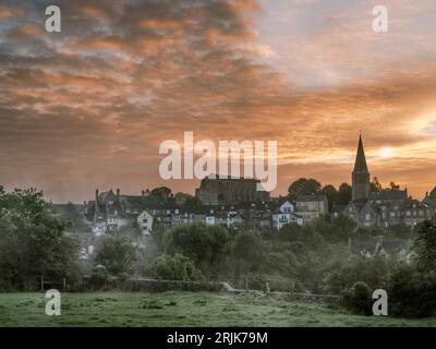 Malmesbury, Wiltshire, England - nach einer kühlen Nacht zieht Nebel entlang des Flusses Avon Valley, während die Sonne über der alten Abtei von t aufgeht Stockfoto