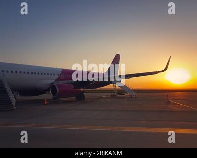 Flugzeug bereit zum Einsteigen am Flughafen mit Blick auf den Sonnenaufgang. Reise- und Urlaubskonzept Stockfoto