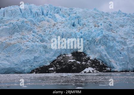 Ein riesiger Eisberg schwebt im Ozean gegen den dunklen Himmel Stockfoto