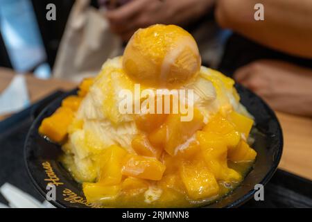 Eine hochauflösende Nahaufnahme eines traditionellen koreanischen Desserts, Bingsu, mit bunten Belägen und Eisspänen Stockfoto