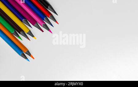 Colored pencils on a white table, top view and copy space. Ready for school stuff. Stock Photo