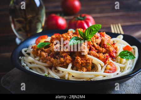 Spaghetti-Nudeln und Tomatensauce mit Hähnchenhack auf Holzuntergrund. Pasta Bolognese. Stockfoto