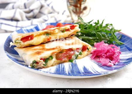 Leckeres Frühstück mit Quesadilla und Eiern. Mexikanische Küche. Trendessen mit Pitabrot, Omelette, Käse, Tomaten Stockfoto