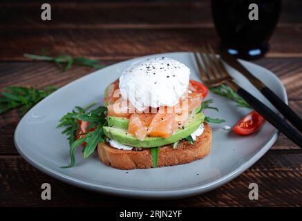 Frühstück Toast. Toast mit Avocado, Lachs und pochiertem Ei. Keto-Diät Stockfoto