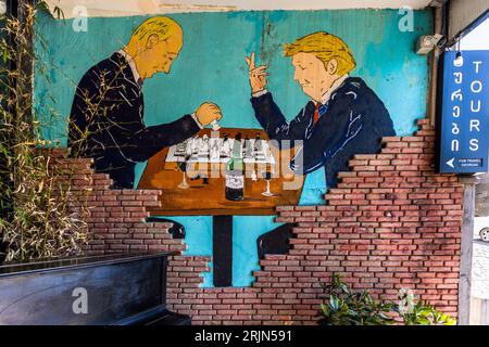 Street Art in Tiflis, Georgia. Donald Trump und Wladimir Putin spielen Schach und trinken georgianischen Wein Stockfoto