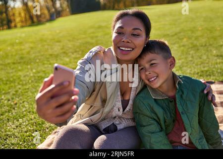Eine glückliche afroamerikanische Mutter, die Selfie mit Sohn, Frau und Junge macht, Herbst, Freude Stockfoto