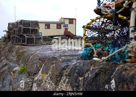Framed by lobster traps, the St Abbs Independant lifeboat station stands ready on the harbour wall Stock Photo