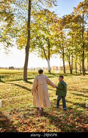 Glückliche Erinnerungen, Mutter und Sohn spazieren im Park, Herbstlaub, Herbstsaison, afroamerikanische Familie Stockfoto