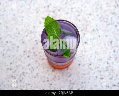 Geeistes Lychee-Getränk mit Minze und natürlichen Farbstoffen aus Schmetterlingserbsenblüten. Stockfoto