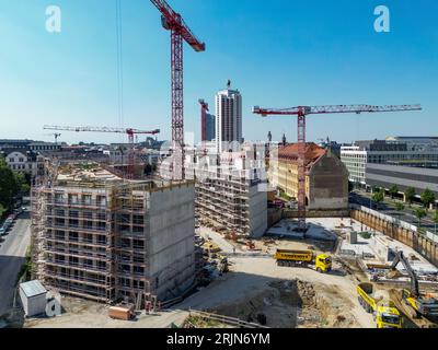 Leipzig, Deutschland. August 2023. Mehrere Krane befinden sich auf der Baustelle des Krystallpalastgebietes (Luftaufnahme mit Drohne). Auf dem rund 18.000 Quadratmeter großen Brachfeld in der Nähe des Stadtzentrums entsteht ein neuer Gebäudekomplex mit vier 4-6 Etagen und einem öffentlichen Innenhof. Das neue Quartier mit Büros, Hotel und Apartments auf dem historischen Gelände am Leipziger Hauptbahnhof soll bis 2025 fertiggestellt werden. Quelle: Jan Woitas/dpa/Alamy Live News Stockfoto