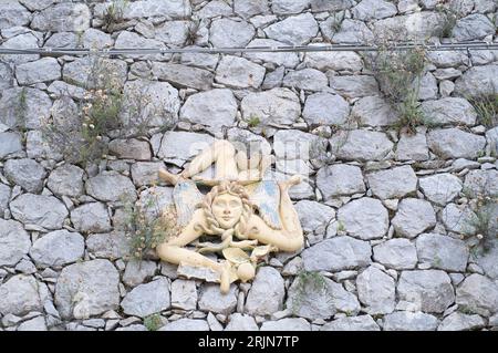 Typische Zeichen der trinacria in sizilien auf einer rustikalen Steinmauer Stockfoto