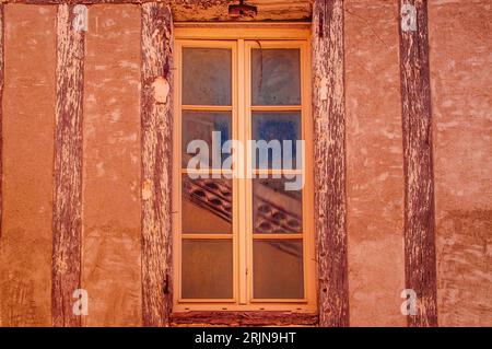 Ein orangefarbenes Fenster in einer rot-orangen Wand Stockfoto