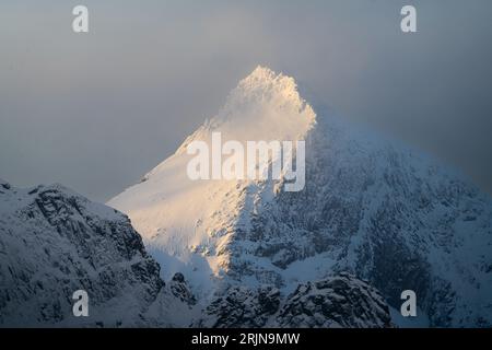 Zwei Personen genießen ein Winterski-Abenteuer, während sie die Seite eines schneebedeckten Berges hinunter gleiten Stockfoto