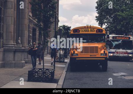 Ein gelber Schulbus, der vor einem Backsteinhaus geparkt ist Stockfoto
