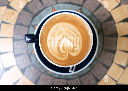 Eine Nahaufnahme einer Tasse Latte mit Hintergrund der Tischoberfläche Stockfoto