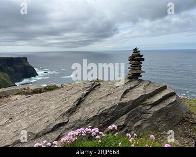 Ein Steinstapel auf einem felsigen Hügel mit Blick auf das Meer auf der irischen Klippe Stockfoto