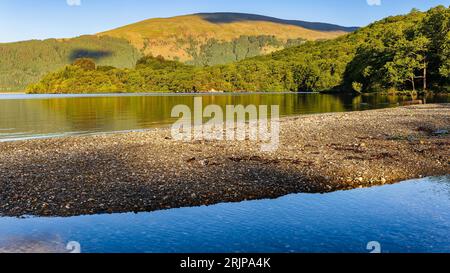 Schöne Reflexionen in einem ruhigen See umgeben von Bergen (Loch Lomond, Schottland) Stockfoto