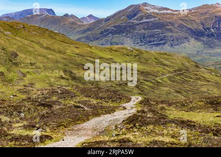 A hiking trail heading towards spectacular mountains with traces of summer snow (Ben Nevis and range, Scotland, UK) Stock Photo