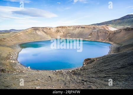 Ein atemberaubender Blick aus der Luft auf einen isolierten Krater in einer Wildnislandschaft, sonnendurchflutet und von Hügeln umgeben Stockfoto