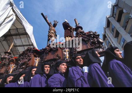 MALAGA, SPANIEN-APRIL,08 2012: Eine Gruppe von Trägern (Costaleros genannt), die einen religiösen Festwagen (bekannt als Tronos) in den Prozessionen trugen, die zum Feiern abgehalten wurden Stockfoto